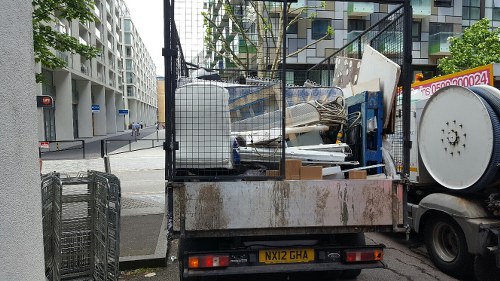 Workers loading waste into a skip on a suburban driveway